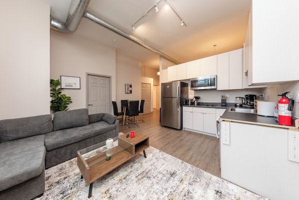 A modern apartment with a living room, kitchen, and dining area.