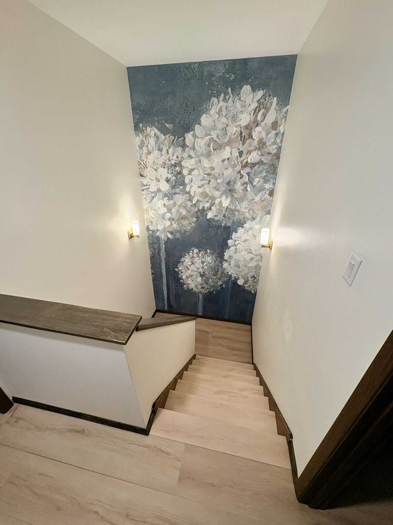 A staircase with wooden steps and a wall with a floral mural.