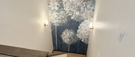 A staircase with wooden steps and a wall with a floral mural.