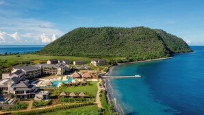 A resort with multiple buildings, a swimming pool, and a beach.
