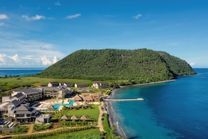 A resort with multiple buildings, a swimming pool, and a beach adjacent to a large body of water. - Intercontinental Dominica Cabrits Resort & Spa, an IHG Hotel (Portsmouth)