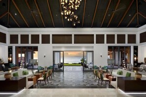 A spacious interior with a large open area, a view of the sea, and a modern chandelier. - Intercontinental Dominica Cabrits Resort & Spa, an IHG Hotel (Portsmouth)