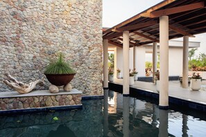 A stone wall with a potted plant and a decorative piece. - Intercontinental Dominica Cabrits Resort & Spa, an IHG Hotel (Portsmouth)