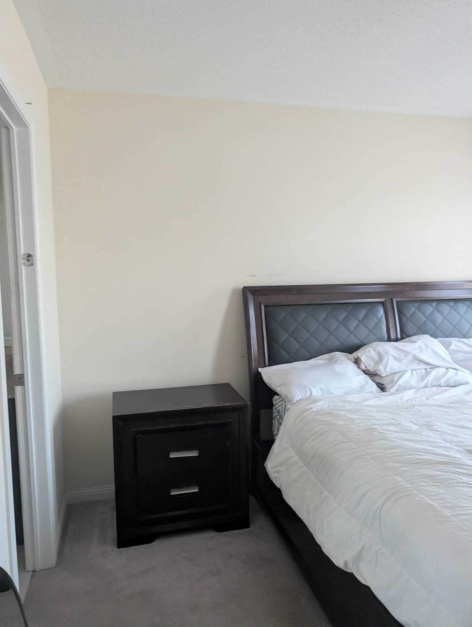 A bedroom with a bed, a nightstand, and a door.. Affordable GTA stay during FIFA 2026