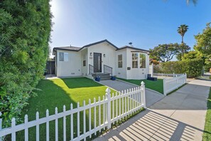 A single-story house with a white exterior, a front porch, and a white picket fence. - Westside LA 4-Bedroom Home · Private Backyard (Los Angeles)