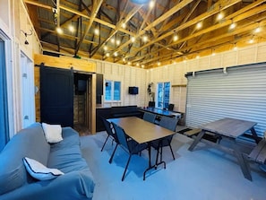 Un intérieur rustique avec des poutres apparentes, un canapé, une table et des chaises.