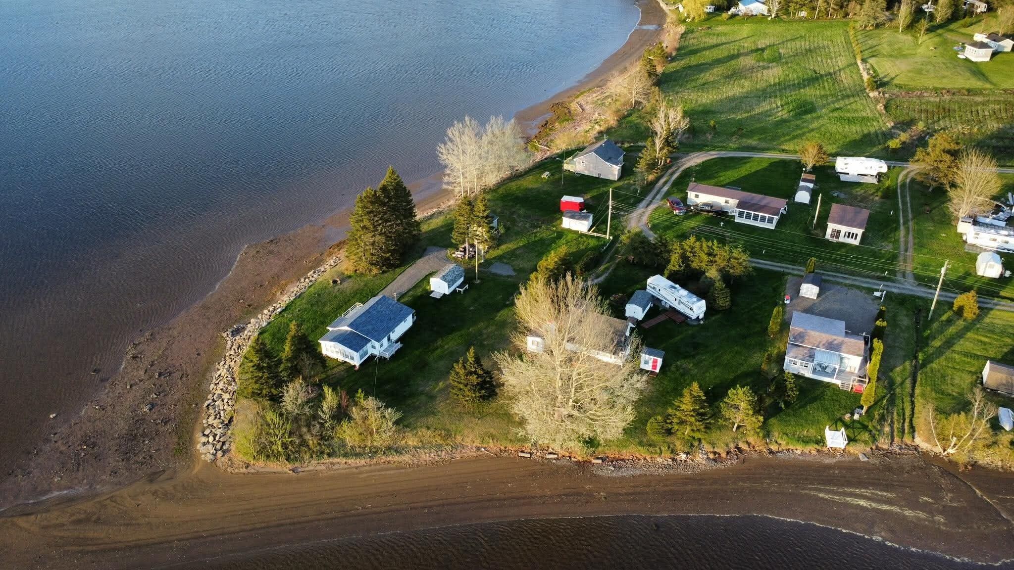 Vista aérea de una zona residencial costera con casas, una playa y una carretera.