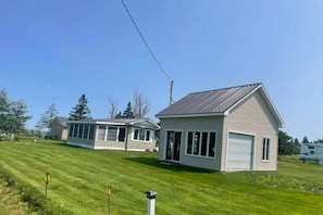 A single-story house with a garage, a covered patio, and a well-maintained lawn.