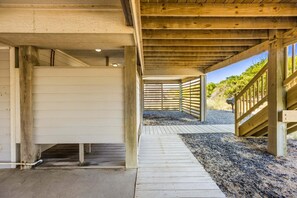 A covered wooden walkway leading to a building entrance with a gravel path beside it. - Oceanfront Retreat w/ Panoramic Views (Kitty Hawk)