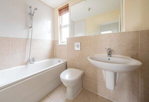 Ein Badezimmer mit Badewanne, Toilette und Waschbecken.