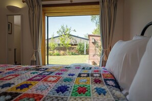 Una camera da letto con un letto grande, vista sul giardino e una finestra con tende.