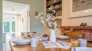 Een ontbijttafel met etenswaren, een bloevas en een krant.