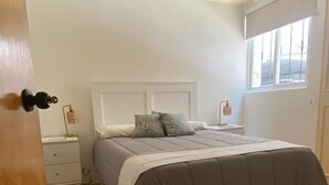 A bedroom with a bed, bedside tables, a window, and a door. - Del Valle Norte, just steps from the WTC, on the ground floor. (Ciudad de México)