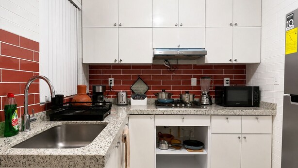 A kitchen with white cabinets, a granite countertop, a stainless steel sink, a microwave, a toaster, and a blender. - Del Valle Norte, just steps from the WTC, on the ground floor. (Ciudad de México)