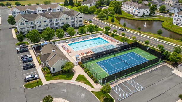 A residential area with apartment buildings, a swimming pool, and a tennis court. - End of the Season Special! Beautiful Rehoboth Beach Condo Pools Tennis Parking (Rehoboth Beach)