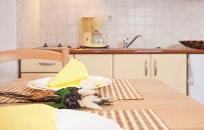 A kitchen with a coffee maker, a sink, and a dining table with a placemat. - Holiday apartment near the sea for 2 people (Punat)