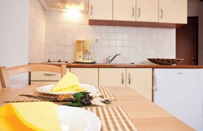 A kitchen with white cabinets, a coffee maker, and a bowl on the counter. - Holiday apartment near the sea for 2 people (Punat)