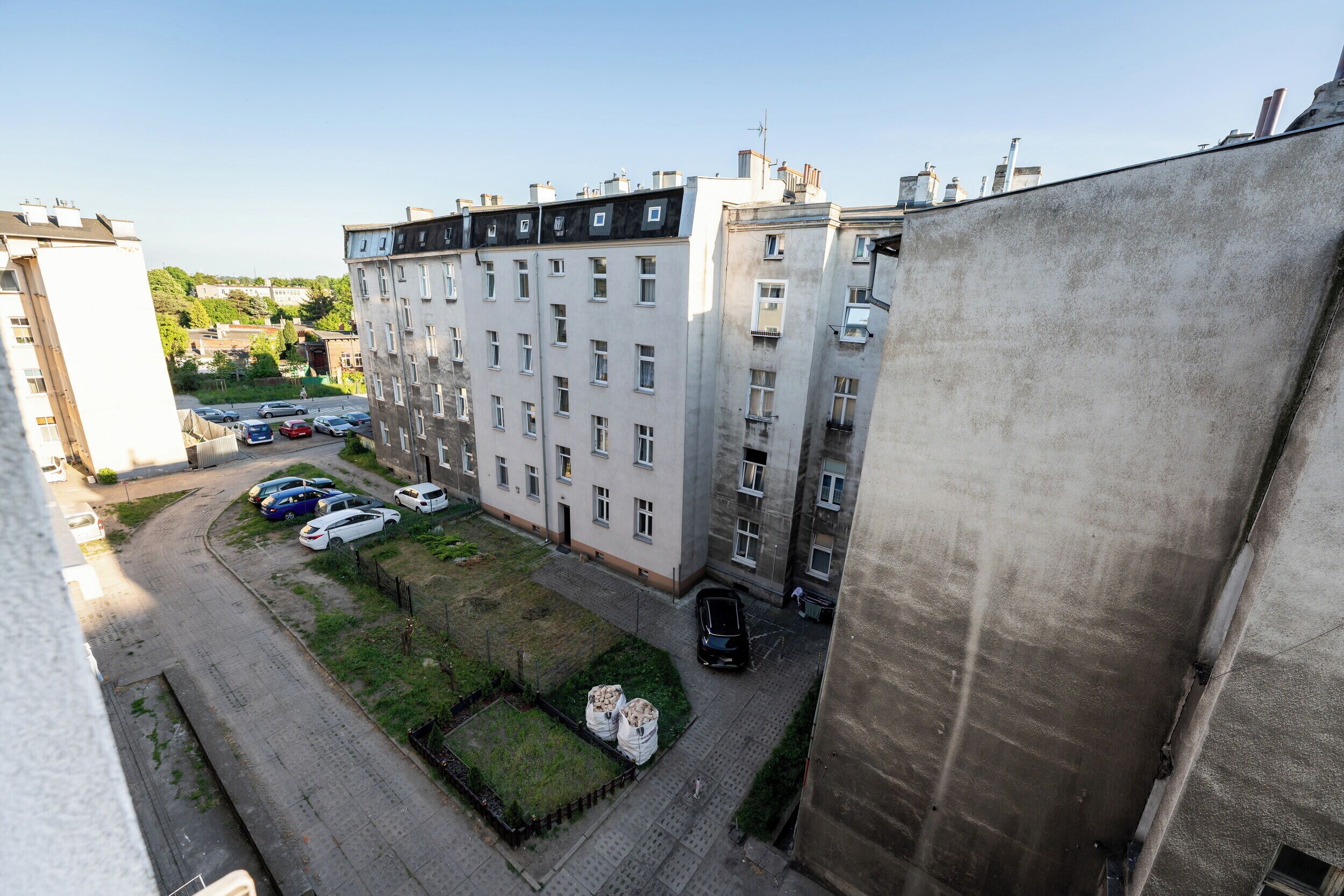 A multi-story residential building with a parking area in front.