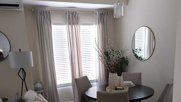 Un salon moderne avec un canapé, une table à manger, des chaises et une plante en pot.