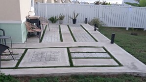 Une terrasse avec des meubles d’extérieur, une petite table et une clôture blanche.