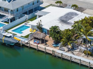Ein Hotel an der Küste mit Pool, Sitzgelegenheiten im Freien und einem Steg.