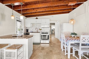 A kitchen with white cabinets, a stainless steel oven, and a wooden ceiling. - Reel-Axed Retreat ~ Pet Friendly, 37.5' Dock, Tiki Hut, Cabana Club w Pool Access (Key Colony Beach)