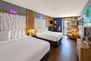 Ein Hotelzimmer mit zwei Betten, einem Schreibtisch, einem Stuhl, einem Fernseher und Blick ins Freie.
