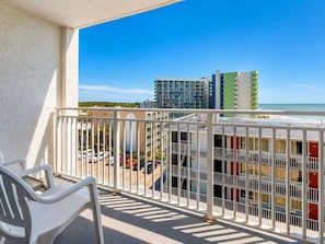 Ein Balkon mit Blick auf Strand und Gebäude.
