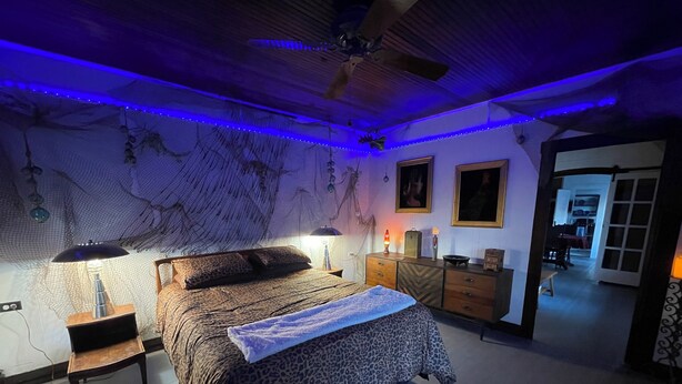 Une chambre à coucher avec un lit, des tables de chevet, une commode et une carte accrochée au mur.