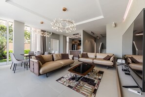 A modern living room with a sofa set, a coffee table, and a chandelier. - Luxe Green Coast Villa Jacuzzi Free Buggy (Himarë)