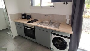 A compact kitchen with a sink, stove, and washing machine. - In a very residential setting close to nature, on the outskirts of the village of La Gacilly (La Gacilly)