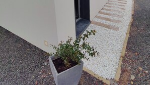 A building with a flat facade, a door, and a small window. - In a very residential setting close to nature, on the outskirts of the village of La Gacilly (La Gacilly)