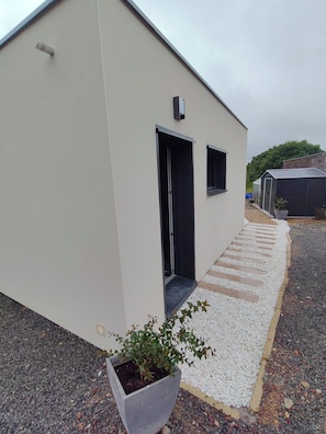 Un edificio con fachada plana, una puerta y un ventanal pequeño.