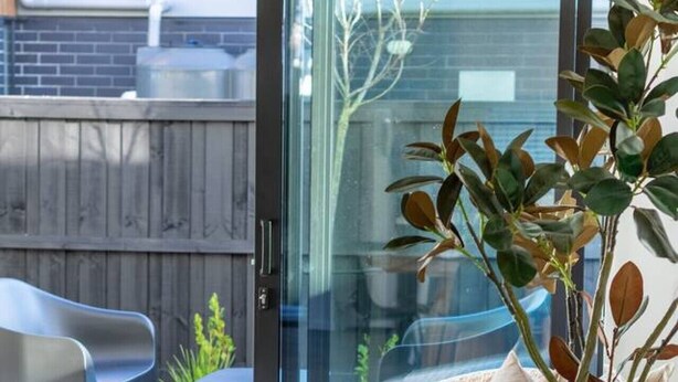 A modern outdoor seating area with a round table, a sofa, and a potted plant. - Family Friendly Home near Fitzgerald Ave + Garage (Christchurch)