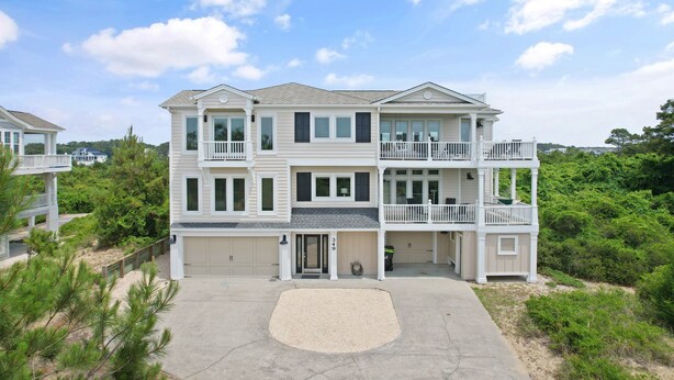A two-story residential building with a front driveway, garage, and a balcony on the upper floor. - "Escape" 5 Bedrooms, 6.5 Bathrooms, ICW Home, Community Pool and Tennis Court! (Supply)