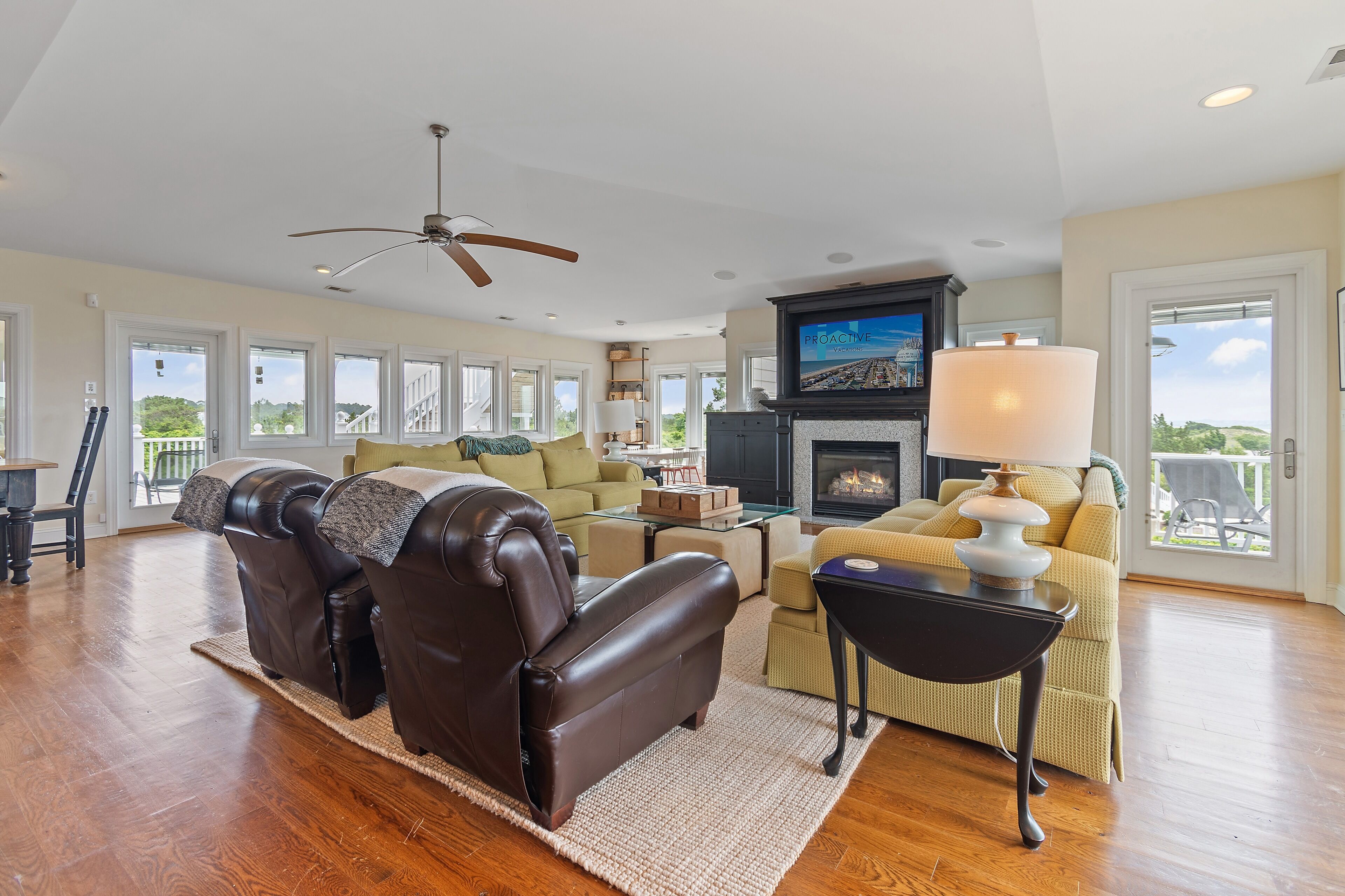 A spacious living room with a fireplace, leather recliners, a sofa, and a television.