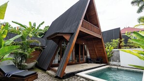 Uma casa moderna com piscina, deck de madeira e uma espreguiçadeira.
