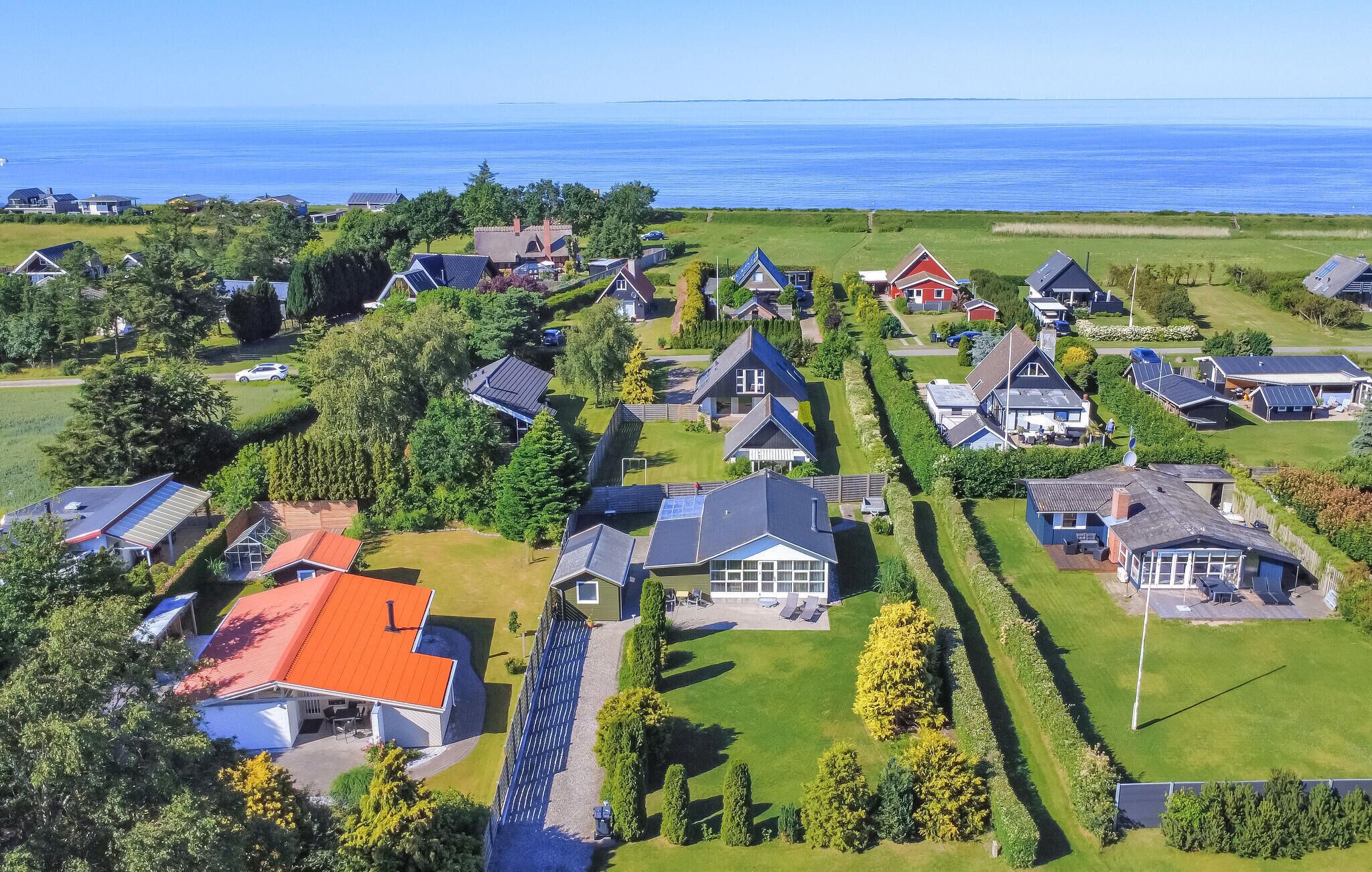Un barrio residencial con casas, paneles solares y vista al mar.