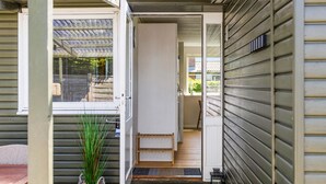 A wooden exterior with a sliding door, a small outdoor seating area, and a potted plant. - Gorgeous home in Otterup with WiFi (Otterup)