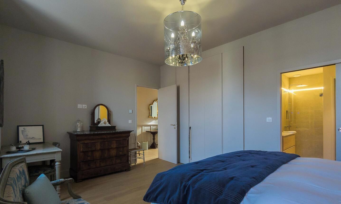 Un dormitorio con cama, cómoda, espejo y armario.