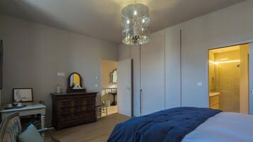 Un dormitorio con cama, cómoda, espejo y armario.