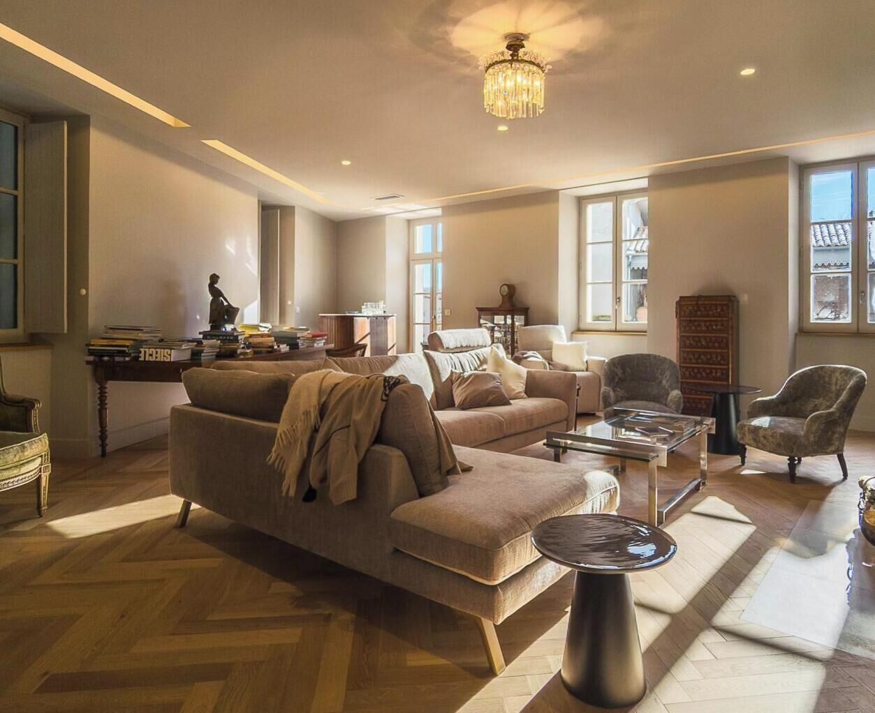 Un salón amplio con un sofá grande, una mesa de centro y un candelabro.