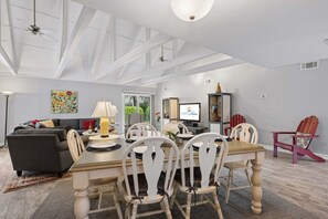 A spacious living room with a dining area, a sofa, a TV, and a fireplace. - 2BR villa with Community Pool, Private Patio, Spacious Kitchen, & Open-Concept Living Spaces (Hilton Head Island)