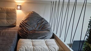 A single bed with a headboard, a bedside table, and a wall-mounted light fixture. - Studio Copa Beach (Rio de Janeiro)