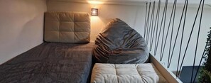 A single bed with a headboard, a bedside table, and a wall-mounted light fixture. - Studio Copa Beach (Rio de Janeiro)