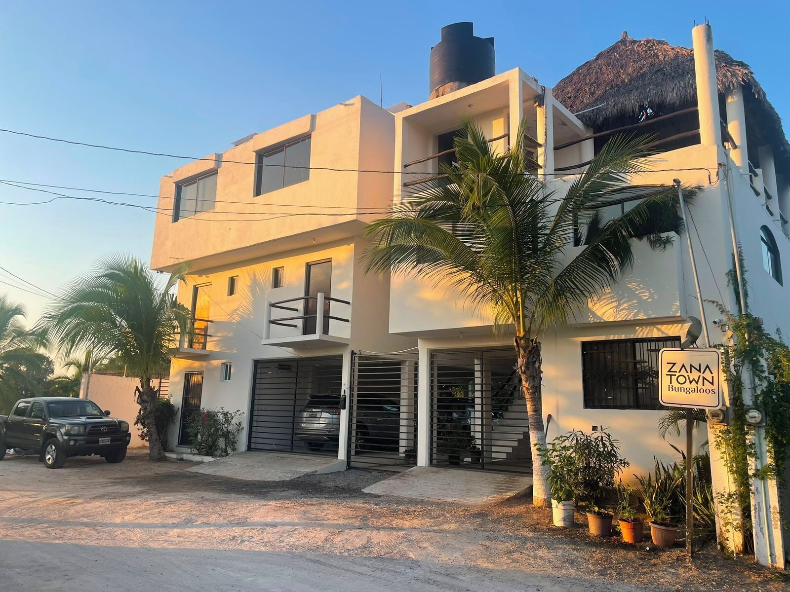 A modern two-story building with a sign indicating 'Zana Town Bungalows.'