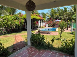 Un espacio exterior cubierto con piscina, jardín y mobiliario.