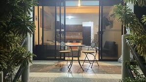 Un'area patio con tavolo e sedie, una sveglia e piante in vaso.