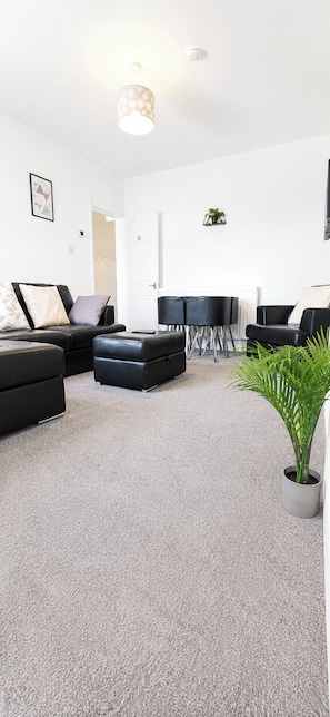 A modern living room with a sofa set, a dining table, and a potted plant. - House Sleeps 7 with WiFi (Gateshead)