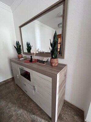 A bathroom vanity with a mirror, two potted plants, a small vase, and a red object on the countertop. - Apartment Sleeps 7 with Balcony (Velez-Malaga)